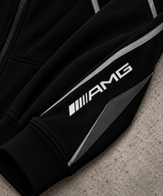 REVLINE Mercedes AMG hoodie sleeve close-up with white AMG logo silver piping and grey concrete background